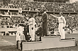 Olimpiada w Berlinie 4 Sierpień 1936 rok. Multimedalista Jesse Owens podczas odgrywania hymnu USA po dekoracji złotym medalem olimpijskim w skoku w dal. W tej konkurencji Jesse Owens pobił rekord świata wynikiem 8 metrów 6 centymetrów.